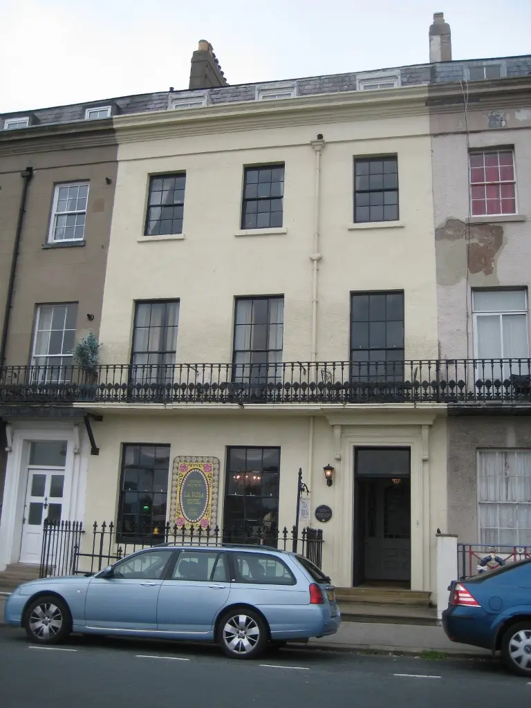 La Rosa Hotel's tall cream Georgian terrace front on East Terrace, with an iron balcony on the first floor